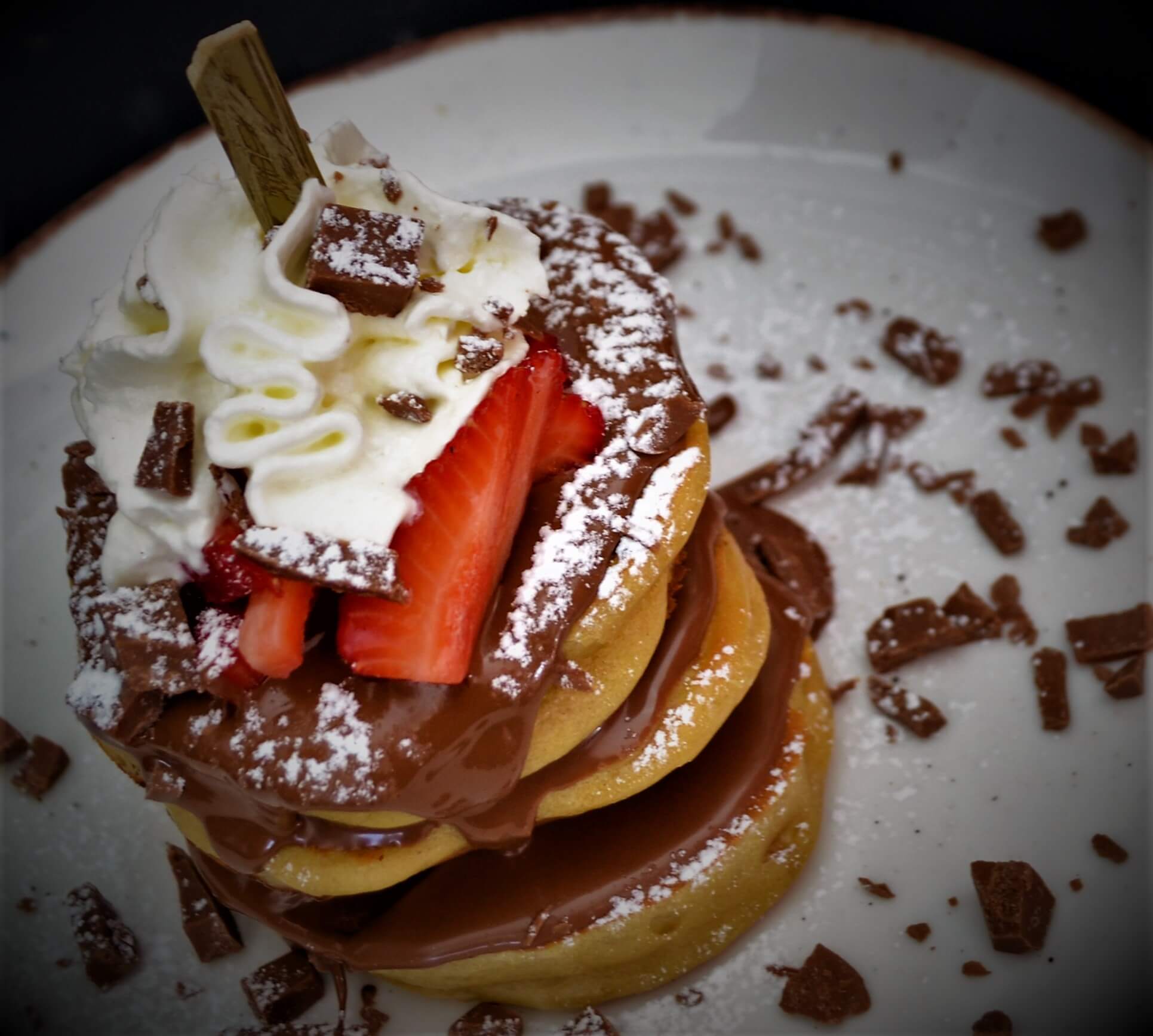 Sweet pancakes with chocolate, strawberries, whipped cream and chocolate chunks