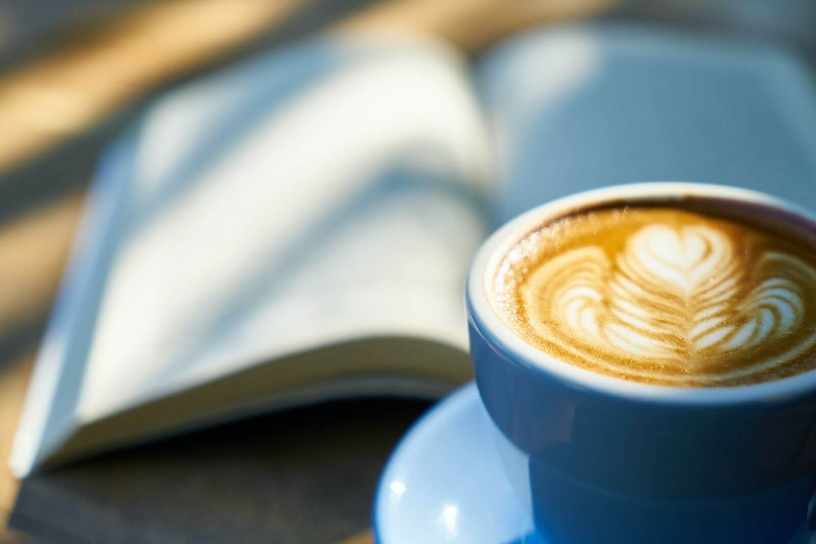a cup of coffee and a book on table